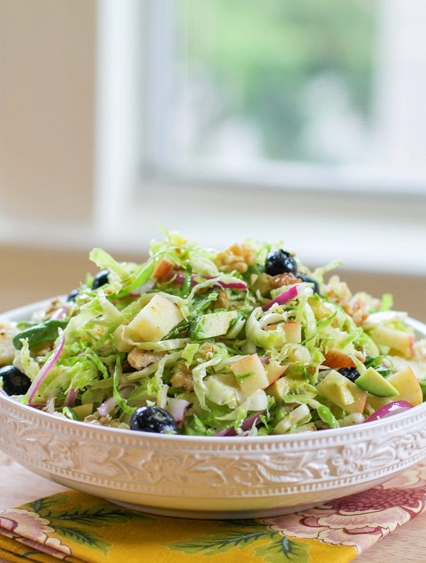 Shaved Brussels Sprouts Salad with avocado, apple, red onion, blueberries, walnuts, and citrus dressing | TheRoastedRoot.net #healthy #salad #sidedish #glutenfree #paleo #vegan