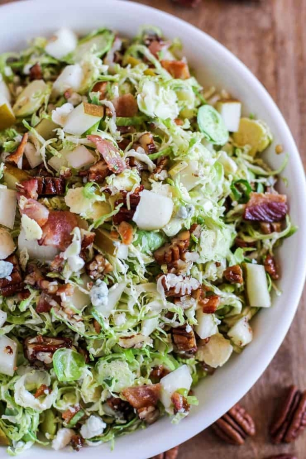 Brussel Sprout Chopped Salad with bacon, pears, candied pecans, blue cheese, and maple-bacon vinaigrette | TheRoastedRoot.com