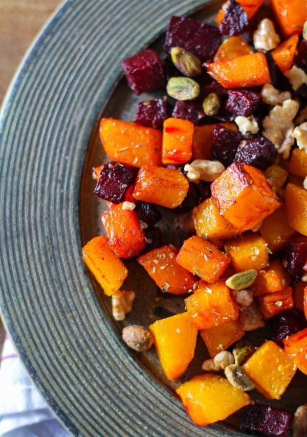 Maple Roasted Butternut Squash and Beets on a rustic wooden plate with a napkin underneath, ready to serve.