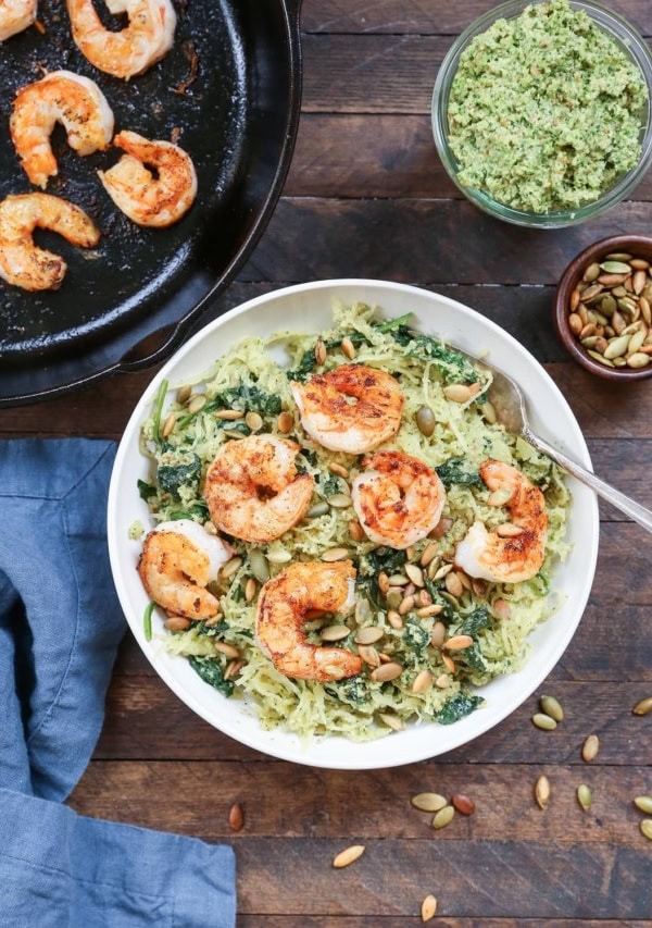 Pesto Spaghetti Squash with Basil-Parsley Pesto and Pan-Seared Shrimp in a bowl with a blue napkin to the side