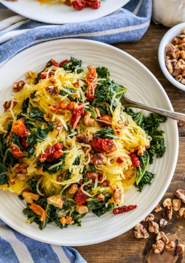 Top down photo of a white plate of Roasted Garlic and Kale Spaghetti Squash with Sun-Dried Tomatoes