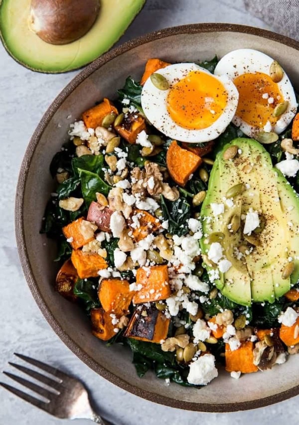 Roasted Sweet Potato Kale Salad with Avocado, Jammy Egg, Pumpkin Seeds, and Walnuts. A filling and nutritious dinner salad | TheRoastedRoot.net