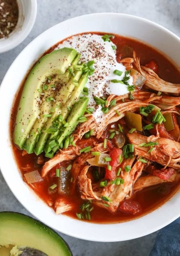 big bowl of chicken enchilada soup with avocado and sour cream