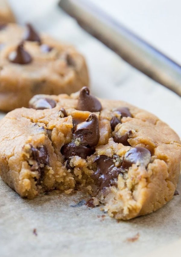 Close up of a peanut butter chocolate chip cookie with a bite taken out with gooey chocolate visible.