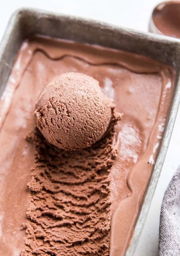 container of chocolate ice cream with scoop taken out