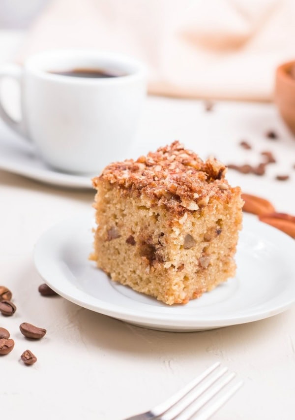 Slice of almond flour coffee cake on a plate with more slices in the background.