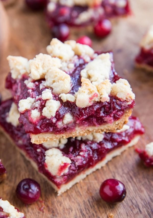 Stack of cranberry crumb bars on a cutting board.