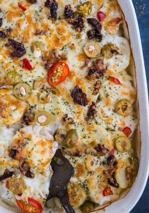 Mediterranean Scalloped Potatoes with sun-dried tomatoes, olives, and roasted bell peppers. A unique spin on classic scalloped potatoes for an amazing side dish!