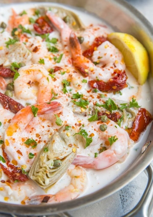 Creamy Tuscan Shrimp Recipe with sun-dried tomatoes, artichoke hearts, and more! Dairy-free, paleo, whole30, keto and delicious!