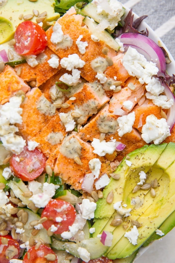 Greek Salmon Salad with cucumbers, avocado, red onion, feta, cherry tomatoes, and an herby dressing. This simple, nourishing recipe is loaded with fresh flavor and is low-carb keto friendly