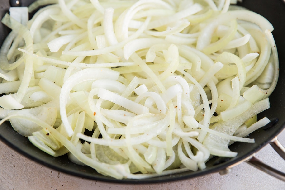 Sliced onions sautéing in a skillet