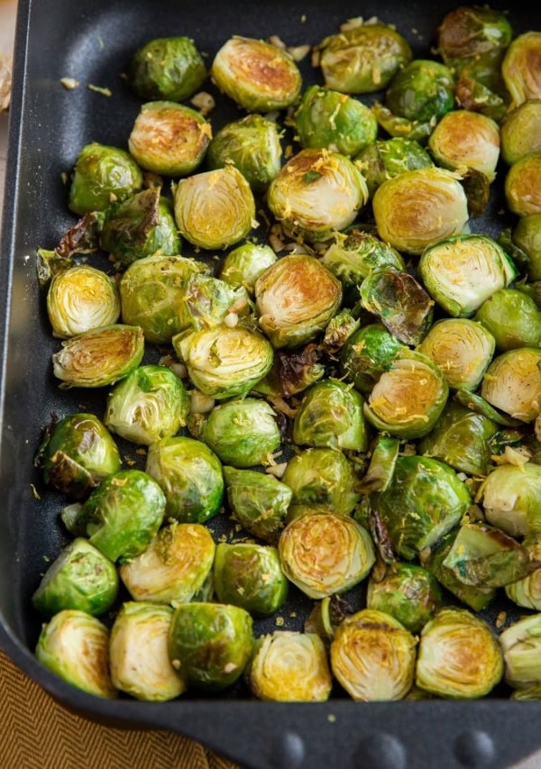 2 pounds of roasted brussel sprouts in a casserole dish with lemon zest on top