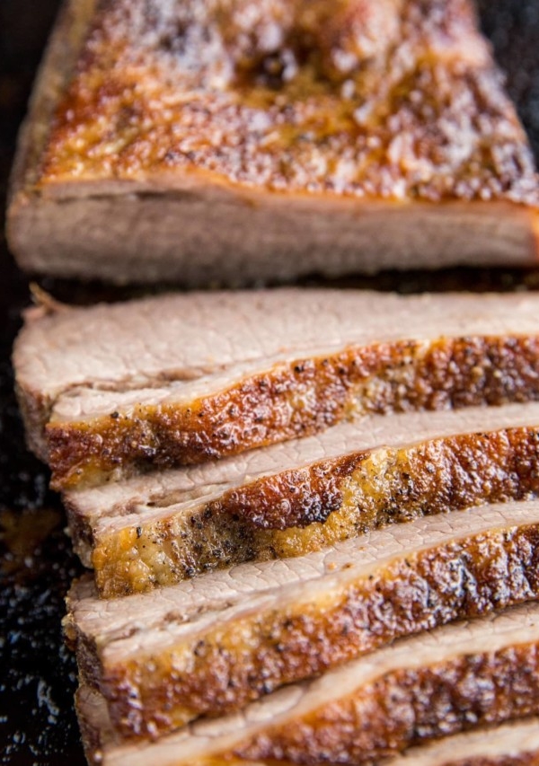 Close up image of sliced brisket on a baking sheet.