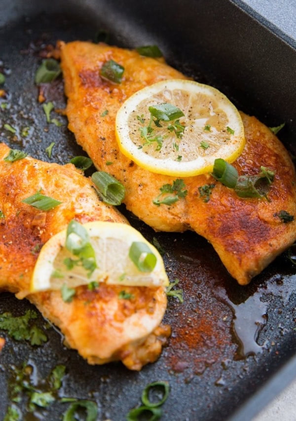 Lemon garlic chicken breasts in a black roasting pan