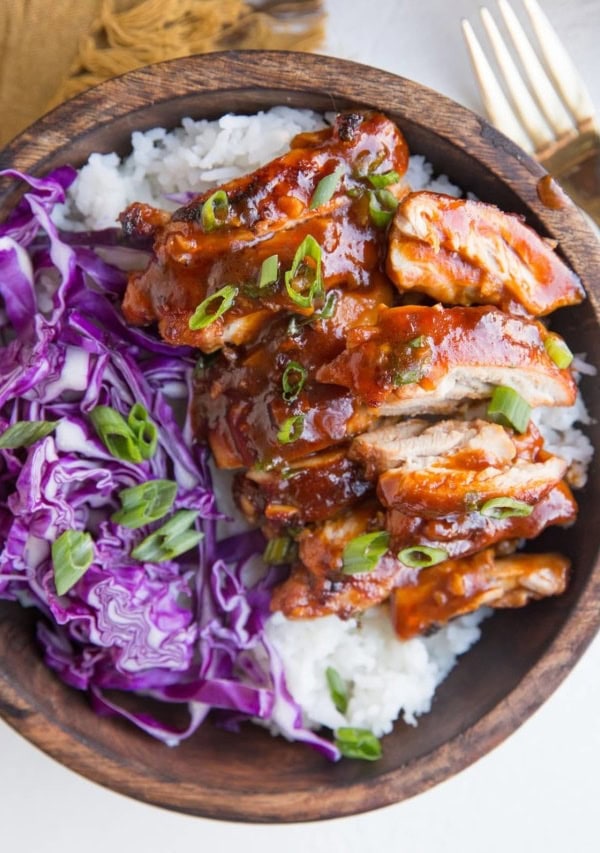 Bowl of Hawaiian BBQ Chicken on top of white rice with red cabbage to the side.