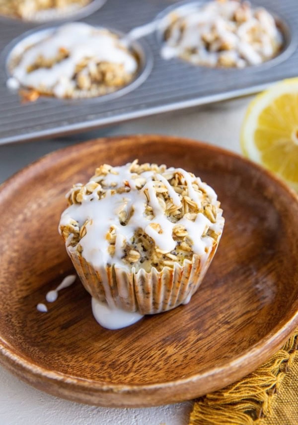 Lemon poppy seed oatmeal muffin on a plate with muffins in the background