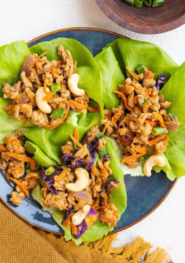 blue plate of Thai ground turkey lettuce wraps with golden napkin to the side.