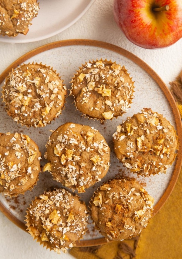 Plate of healthy apple muffins with a napkin and apple to the side