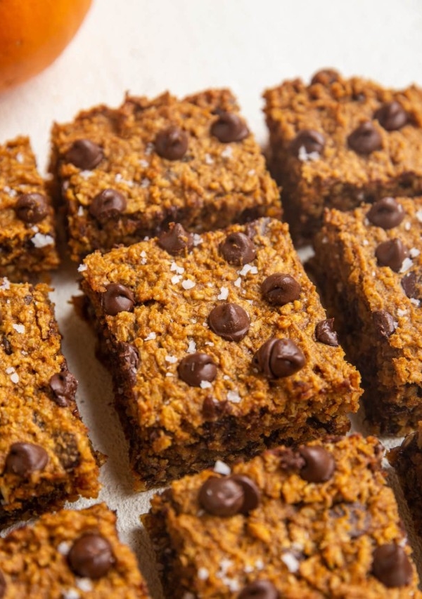 Sliced pumpkin bars on a white backdrop.