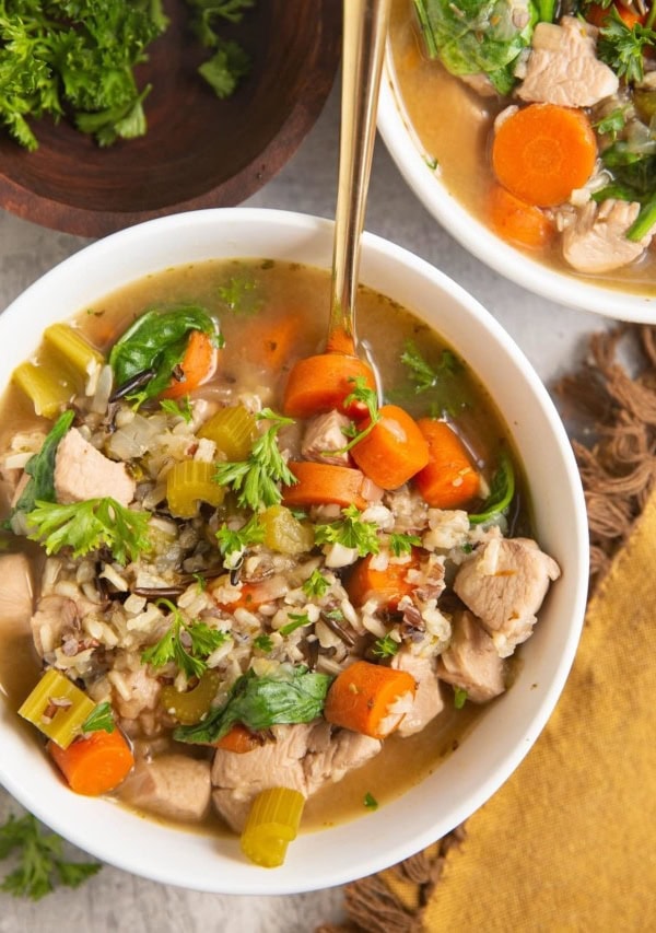 Top down image of two bowls of wild rice chicken soup.