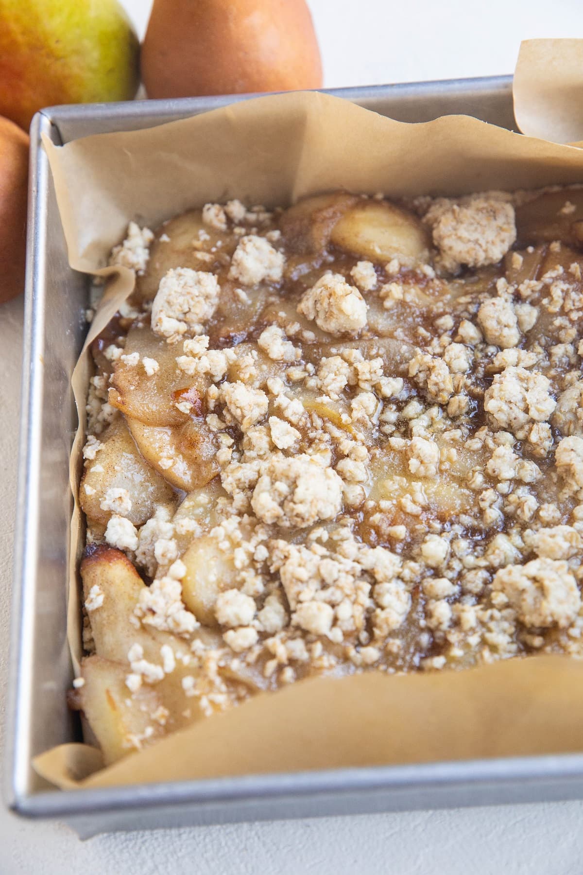 Baking pan of pear crumb bars, cooling to be sliced.