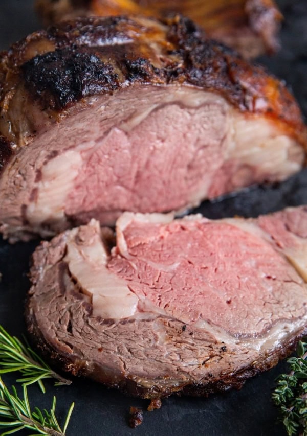 Garlic Herb Prime Rib on a cutting board, sliced into a steak.