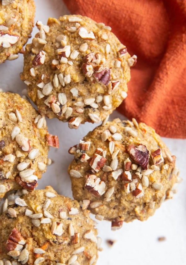 Top down close up image of healthy Morning Glory Muffins sitting on a white backdrop with a red napkin to the side.