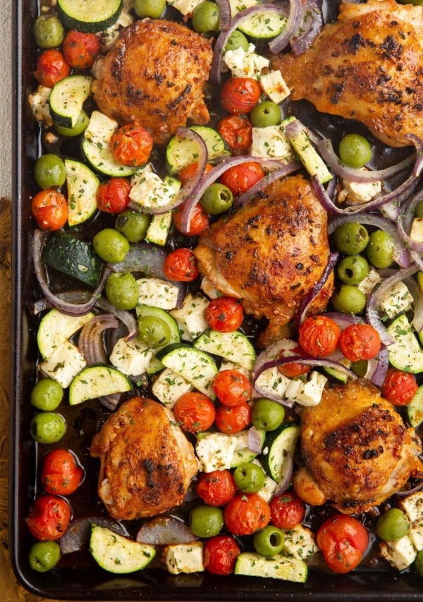 Large sheet pan with crispy chicken and vegetables, ready to be served.