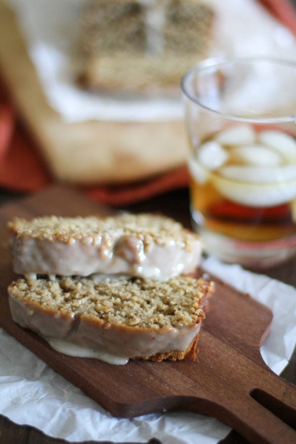 Two slices of eggnog bread on a cutting board with the rest of the loaf in the background.