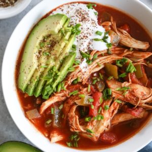 big bowl of chicken enchilada soup with avocado and sour cream