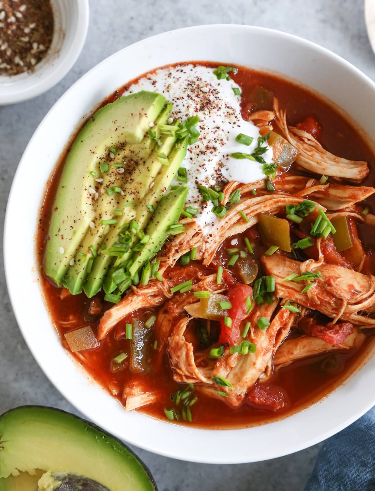 big bowl of chicken enchilada soup with avocado and sour cream