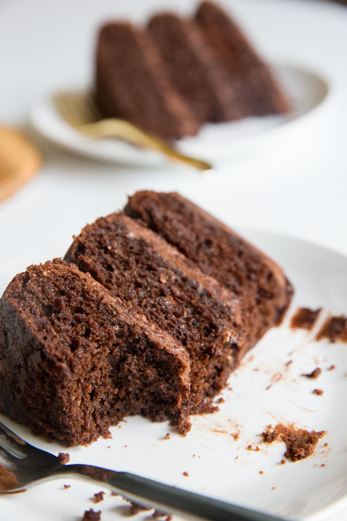 Large slice of cake on a plate with a bite taken out.