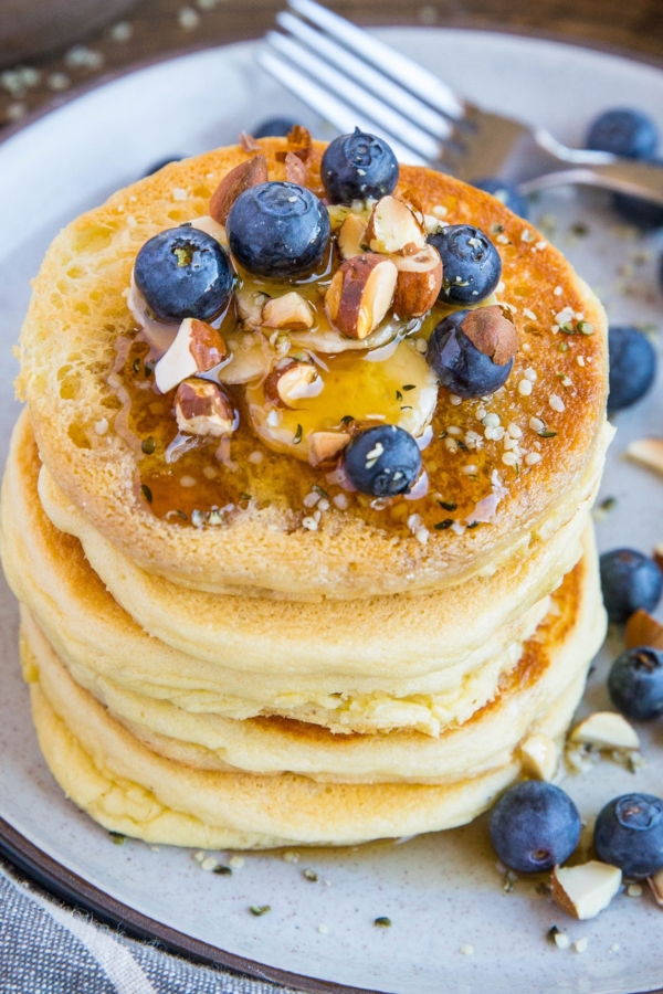 Almond flour pancakes on a plate with blueberries and banana, ready to eat