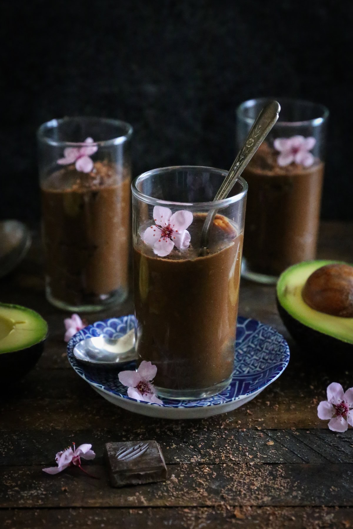 Three small glasses with chocolate mousse inside, ready to serve.