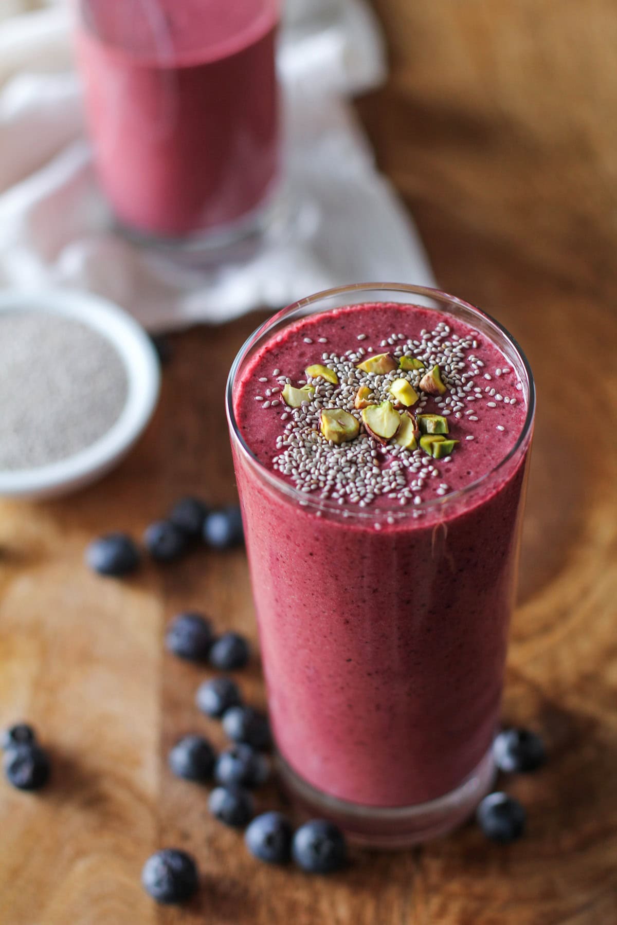 Beet Berry Apple Smoothie on a wooden background with fresh berries all around.