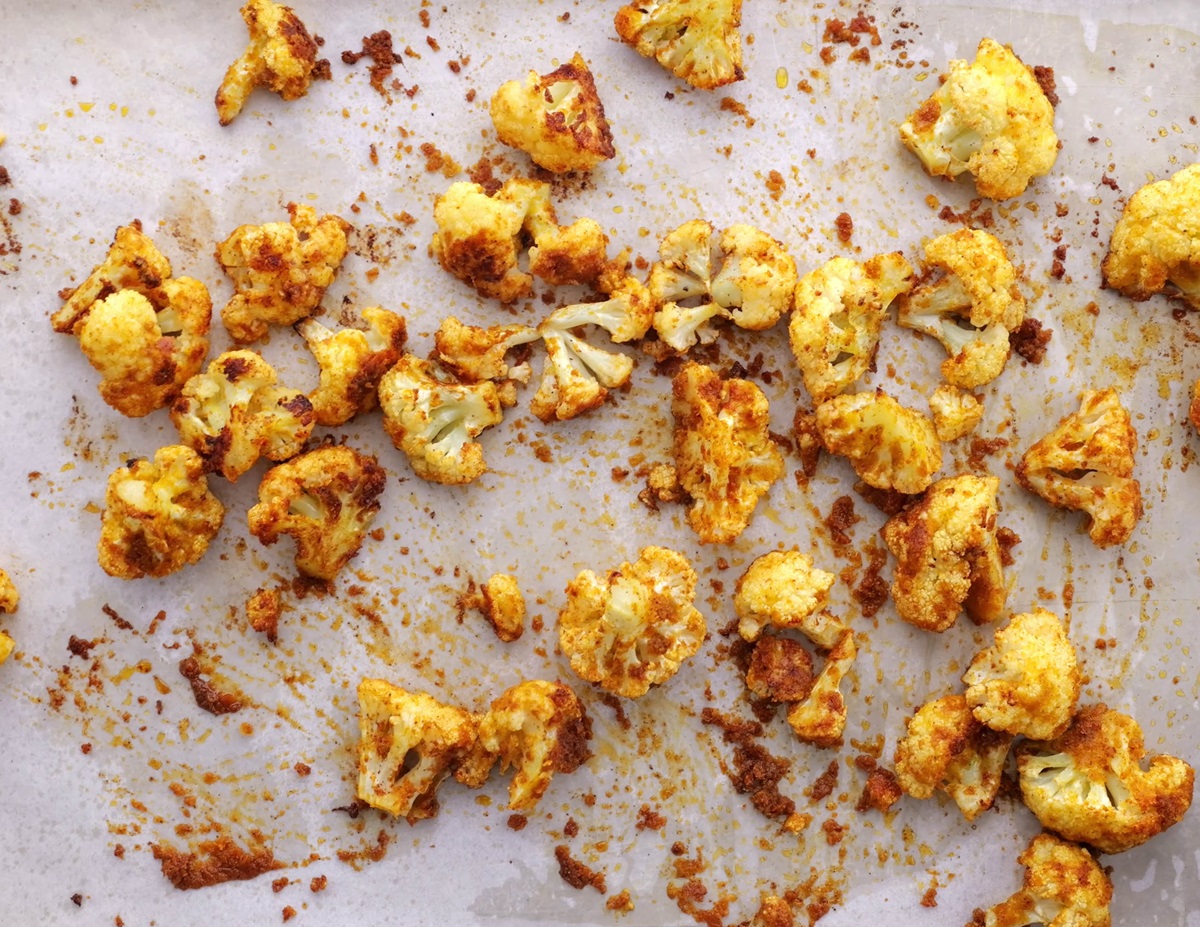 Baking sheet with cheesy vegan roasted cauliflower fresh out of the oven, and ready to serve.