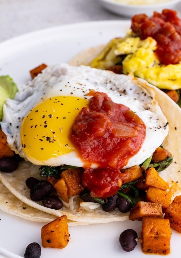 White plate with two breakfast tacos, ready to eat for a healthy breakfast.