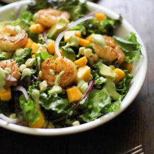 Shrimp salad in a large salad bowl with a fork to the side, ready to eat.