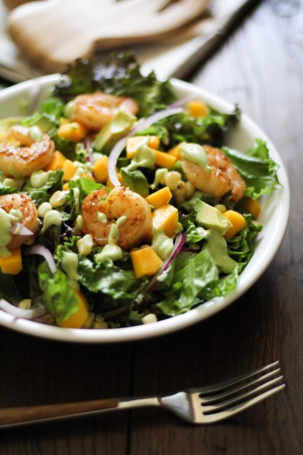 Shrimp salad in a large salad bowl with a fork to the side, ready to eat.