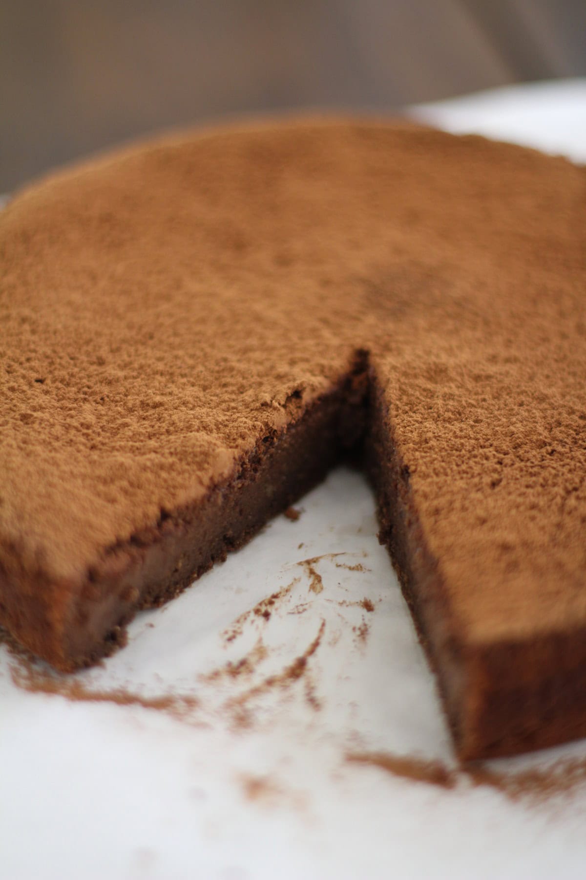 Whole chocolate cake with a slice taken out.