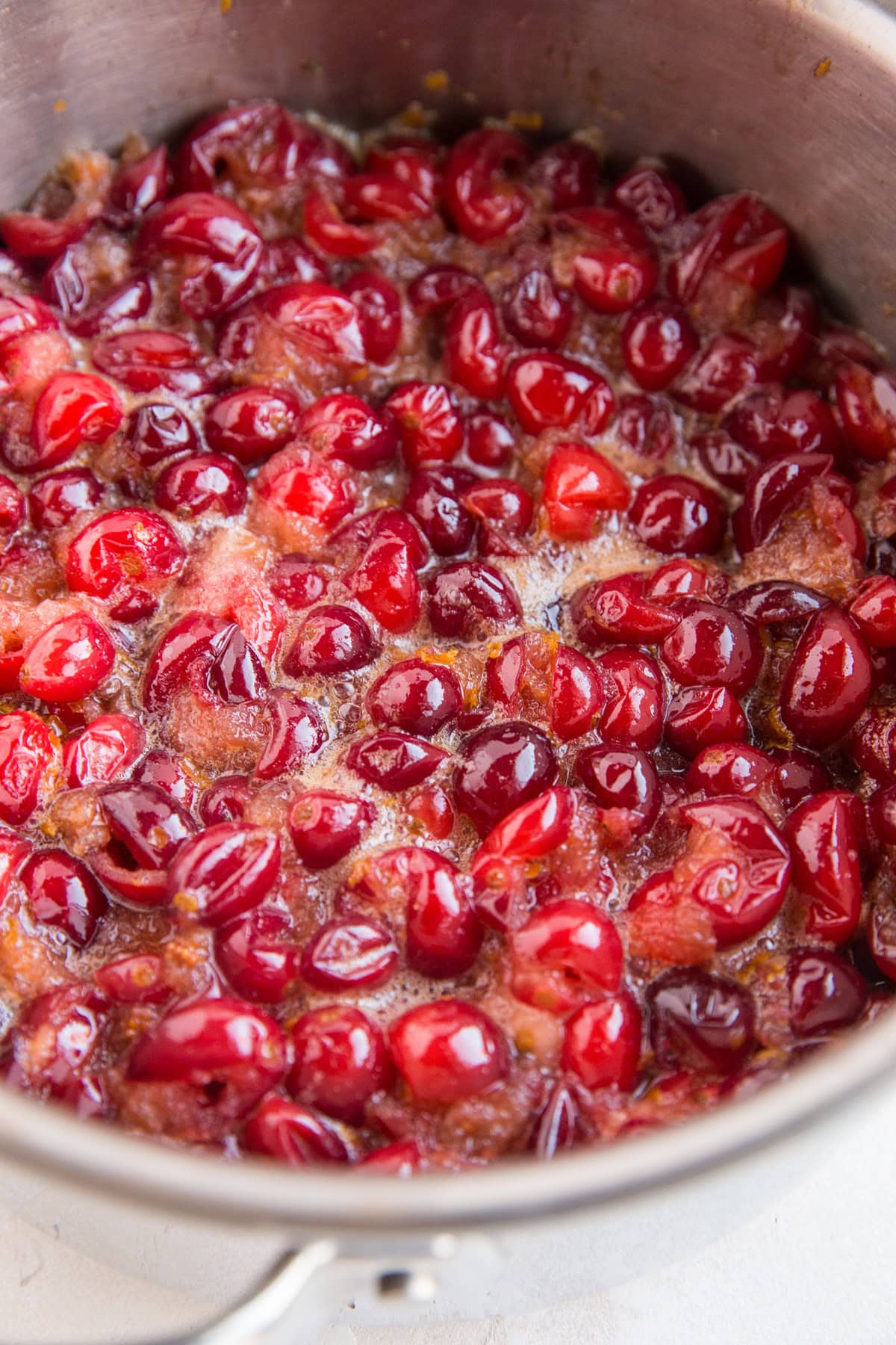 Cranberry sauce ingredients boiling in a saucepan to make cranberry orange sauce.