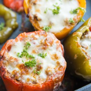 Large casserole dish filled with taco stuffed peppers with cheese on top, fresh out of the oven and ready to serve.