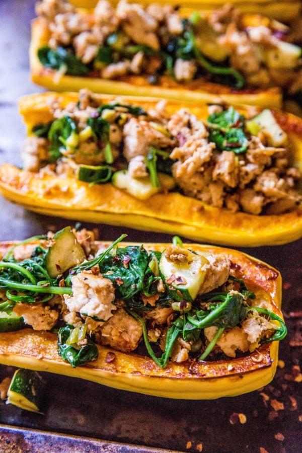 Baking sheet of stuffed delicata squash.