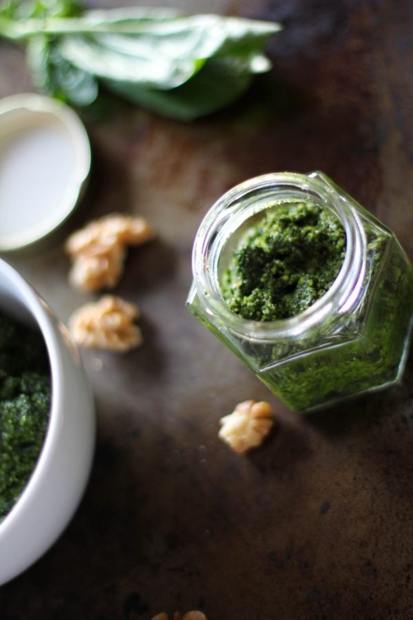 Kale Pesto in a jar with walnuts to the side.