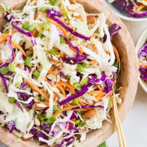 Big bowl full of homemade no mayo coleslaw with a golden spoon, ready to serve.