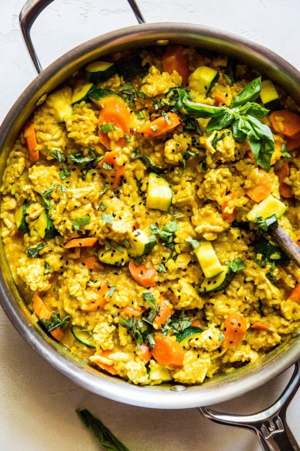 Stainless steel skillet full of ground turkey curry with rice and vegetables.