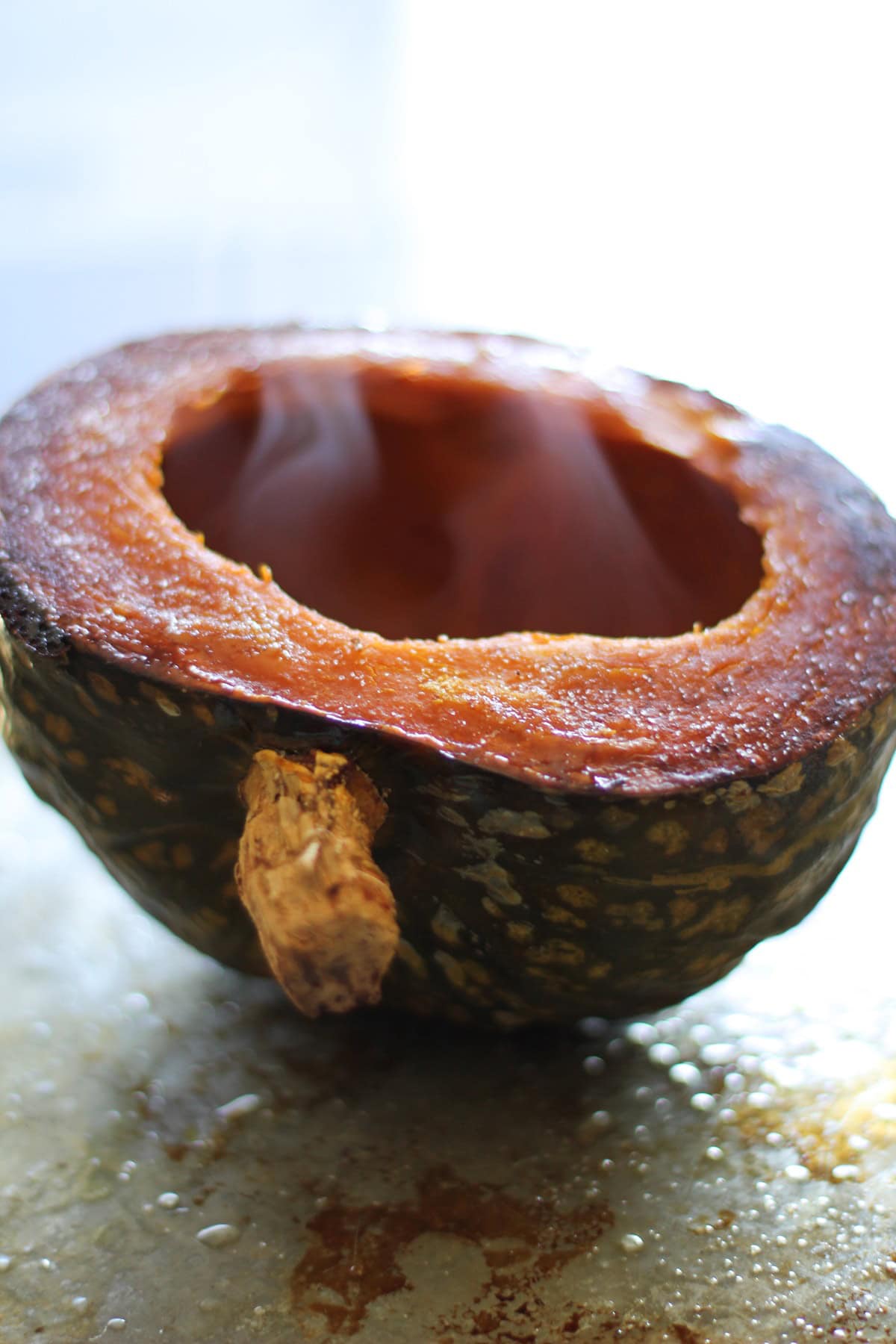 Roasted Kabocha Squash steaming on a baking sheet, fresh out of the oven.