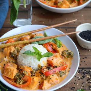 Bowls of red curry salmon with sprinkles of sesame seeds.