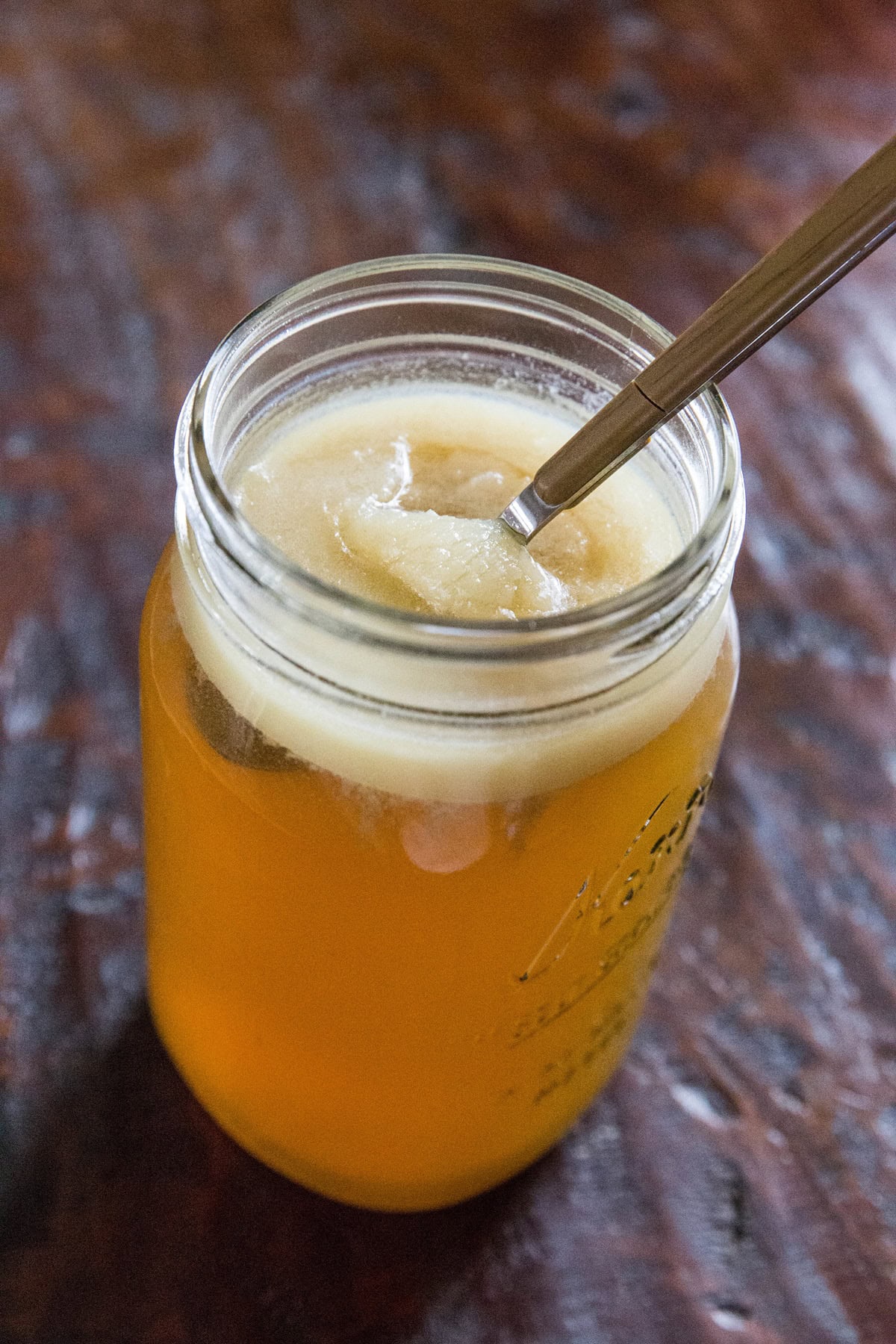 Large jar full of turkey bone broth with gelatin on top.