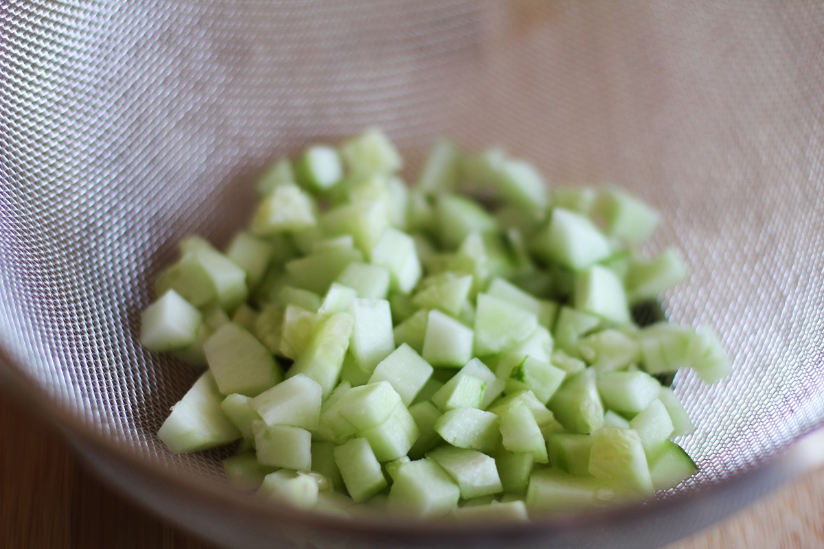 Strainer with chopped cucumber draining.